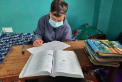 中北部・ドラカ郡の自宅で勉強をする12歳のアショクくん。ネパールでは4月から5月にかけて感染者が急増し、学校が休校している。(ネパール、2021年6月撮影)