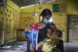 アッサム州にある保健センターで、赤ちゃんに母乳をあげる母親。(インド、2021年7月9日撮影)