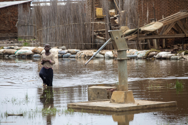 浸水した井戸のまわりを歩く子ども。洪水の被害により、この地域では1年で5万人以上が国内避難民になった。(ブルンジ、2021年3月撮影)