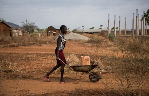 南スーダンのジュバ郊外で、未処理の水を入れた容器を一輪車で毎日運ぶアマルさん（17歳）。「川まで歩かなくてよくなったので、勉強する時間が増えましたが、水はまだ汚れているので、弟妹が水を飲んで病気にならないか心配です」と話します。