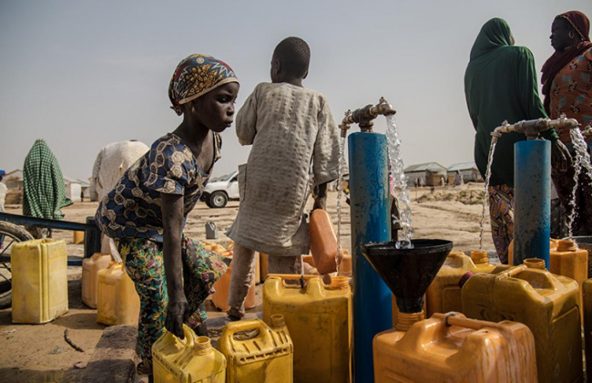 水容器に水を貯める女の子。ナイジェリアのボルノ州の州都マイドゥグリにある酷なん避難民キャンプで暮らしている。