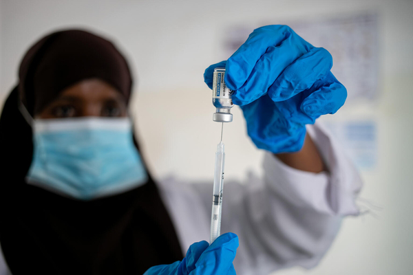 ガローウェの保健所で、COVID-19ワクチンを注射器に充填し、予防接種の準備をする医療従事者。 (ソマリア、2021年10月2日撮影)
