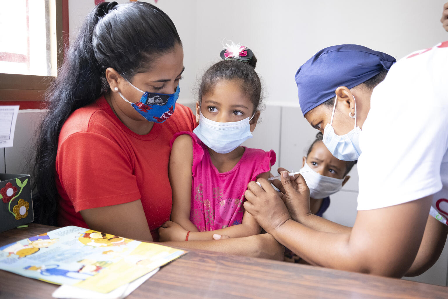 はしかの予防接種を受ける6歳の女の子。ユニセフは、未接種の子どもたちが予防接種を受けられるように、「予防接種の日」を設けて予防接種を呼びかけるなど、様々な予防接種キャンペーンを実施している。（ベネズエラ、2021年9月3日撮影）