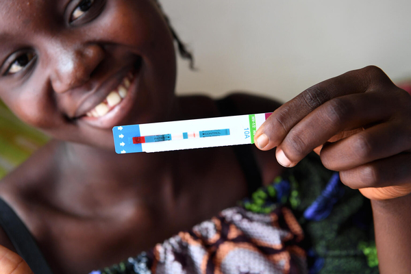 首都キンシャサの保健センターで、陰性のHIV検査結果を手に持つ妊娠5カ月目のデニースさん。 (コンゴ民主共和国、2021年8月撮影)
