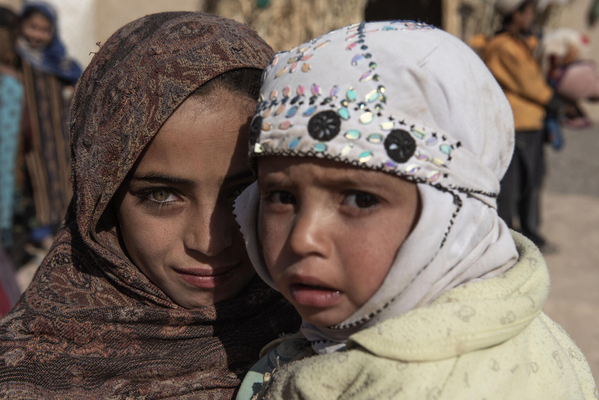 移動式保健・栄養チームによる健康診断で栄養不良と診断されたアリちゃんと、12歳の姉のサミヤさん。(アフガニスタン、2021年11月18日撮影)