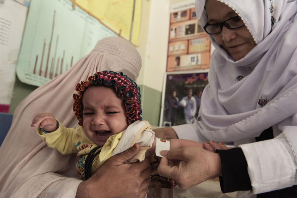 カンダハールにあるクリニックで、上腕計測メジャーを使って栄養状態のチェックを受ける子ども。(アフガニスタン、2021年11月15日撮影)
