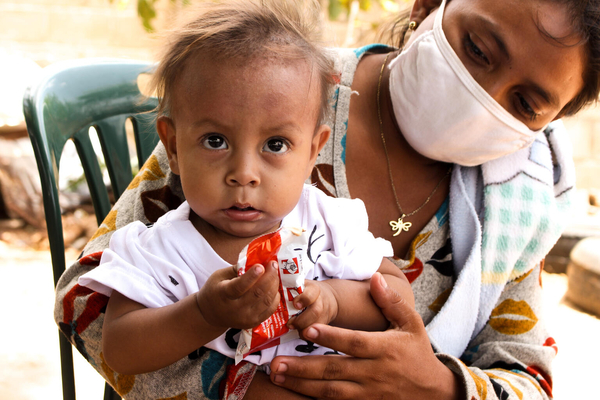 スリア州で行われた栄養状態の検診で提供された、すぐに食べられる栄養治療食(RUTF)を口にする1歳のヘススちゃん。(ベネズエラ、2021年6月撮影)