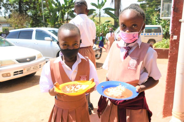 再開二日目の小学校で、給食を手に持つ子どもたち。(ウガンダ、2022年1月11日撮影)