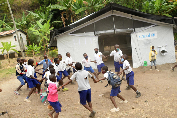 休み時間に、教室の前で輪になって遊ぶ小学生たち。ユニセフ支援の高性能テントの教室で学んでいる。(ウガンダ、2022年1月31日撮影)