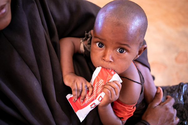 保健センターで、すぐに食べられる栄養治療食(RUTF)を口にする子ども。(ソマリア、2022年2月3日撮影)