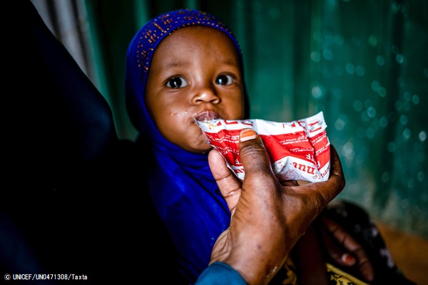 保健センターで、すぐに食べられる栄養治療食(RUTF)を口にする子ども。(ソマリア、2021年5月撮影)