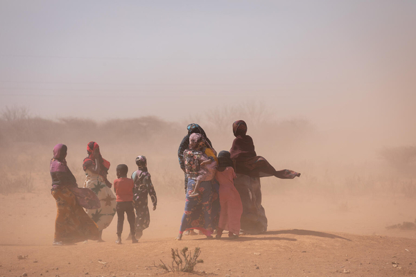 深刻な干ばつの被害を受けているソマリ地域の村で、砂埃が舞う中歩く人たち。(ソマリア、2022年1月撮影)