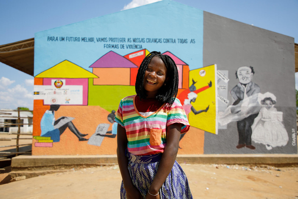 「18歳未満での結婚は早すぎることと、私たちの権利に反していることを学んだ」と話す14歳のマーラさん。後ろの壁には、女の子は学校にいるべきで児童婚をするべきではないという意味の絵が描かれている。(モザンビーク、2021年12月撮影)
