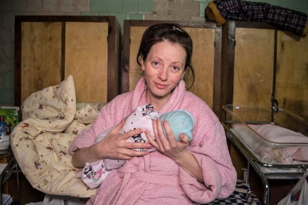 キエフ産婦人科センターの地下に仮設で設置された産科病棟のベッドで、生まれたばかりのベラちゃんを抱く母親。紛争下でも安全に出産できる場所を探して、キエフ郊外の自宅から2日かけて歩いてきた。(ウクライナ、2022年3月7日撮影)