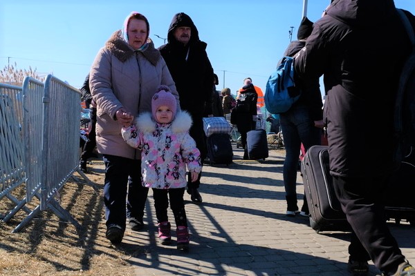 ウクライナと国境を接するポーランドのメディカにたどり着いた家族。ボランティアからの支援で衣類、毛布、温かい食べ物や飲み物、衛生用品などの必要な物資が配布されている。(ポーランド、2022年3月11日撮影)