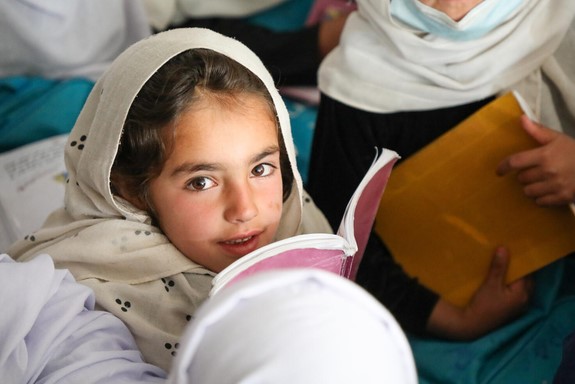 ユニセフが支援する地域学習センターで、6年間の初等教育課程を3年間で学ぶ速習型学習カリキュラムを受ける女の子。速習型学習は、学齢期になっても学校に通っえなかった子どもや学校教育を中断した子どもにとって、よりよい教育支援につながる。(アフガニスタン、2022年3月12日撮影)