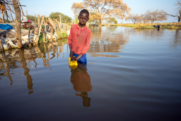 洪水によって溢れた水を汲む13歳のマチエイさん。(南スーダン、2022年1月撮影)