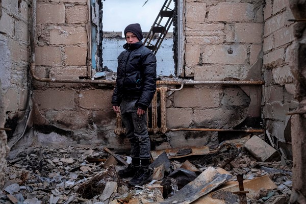 破壊された自宅で立ちすくむ12歳のダニーロさん。彼の祖母は「帰る場所もなければお金も食料もない。すべてが焼かれてしまった」と話す。(ウクライナ、4月16日撮影)