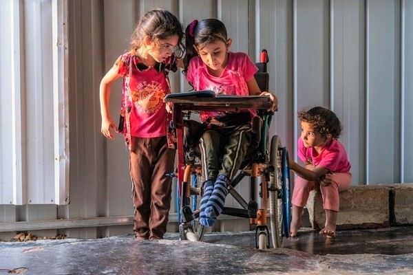 生後8カ月で受けた手術によって体の一部に麻痺が残ったアシールさん（8歳）。「車いすを持てるようになる前は、ベビーカーに乗り兄に押してもらって移動していました」と話す。（ヨルダン、2020年11月撮影）