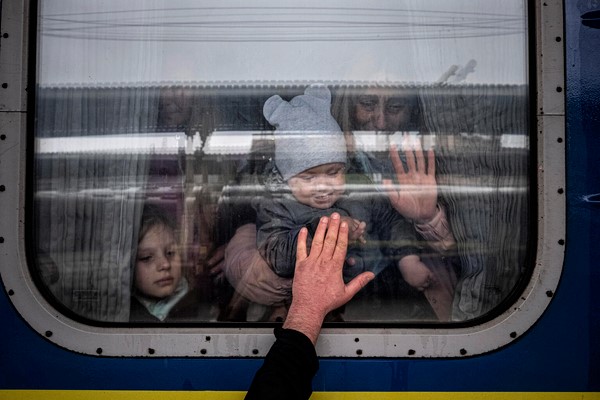 ハルキウから避難するための電車に乗り、残る家族に別れを告げる親子。(ウクライナ、2022年4月20日撮影)