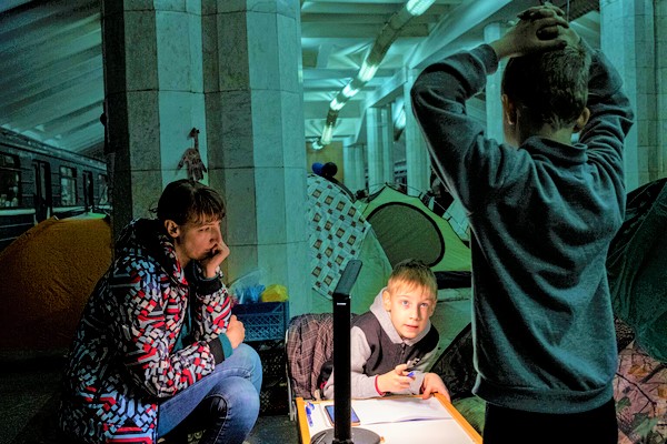 避難したハルキウの地下鉄の中で、母親に見守られながら算数の宿題をする7歳のユリアさん。(ウクライナ、2022年4月撮影)