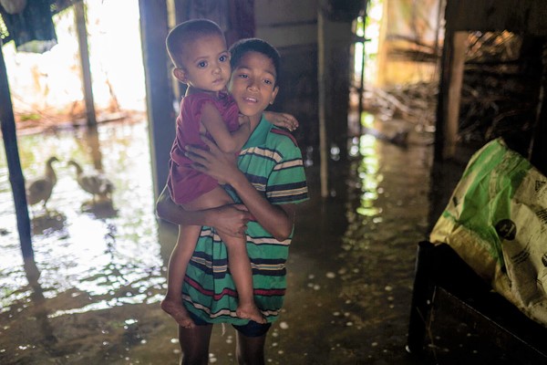 過密状態の避難所は家族で過ごせるスペースがなく、浸水した自宅に戻ってきた子どもたち。(バングラデシュ、2022年6月19日撮影)
