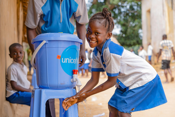 ユニセフの支援により、ムバンダガの小学校に設置された手洗い場で手を洗う9歳のタビサさん。(コンゴ民主共和国、2022年5月6日撮影)