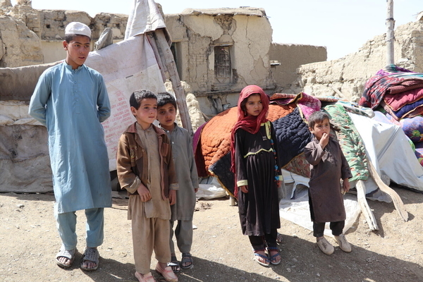 パクティカ州・ガヤン地区で倒壊した自宅の前に立つ子どもたち。(アフガニスタン、2022年6月22日撮影)