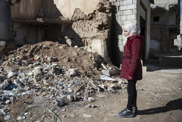 ダマスカス郊外で、紛争により破壊された自宅の跡を見つめる11歳のアミナさん。(シリア、2022年2月撮影)