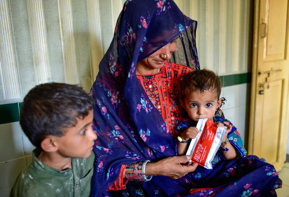 バロチスタン州にある保健センターで、すぐに食べられる栄養治療食(RUTF)を口にする栄養不良の生後10カ月のザリーンちゃん。(パキスタン、2022年5月撮影)