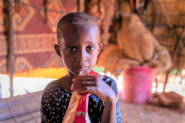 国内避難民キャンプで、すぐに食べられる栄養治療食(RUTF)を口にする栄養不良の4歳のヌラちゃん。(エチオピア、2022年4月撮影)