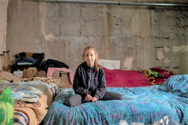 北東部ハルキウで、空襲や砲撃から逃れるため地下駐車場に家族と避難した9歳のアリーナさん。(ウクライナ、2022年5月撮影)