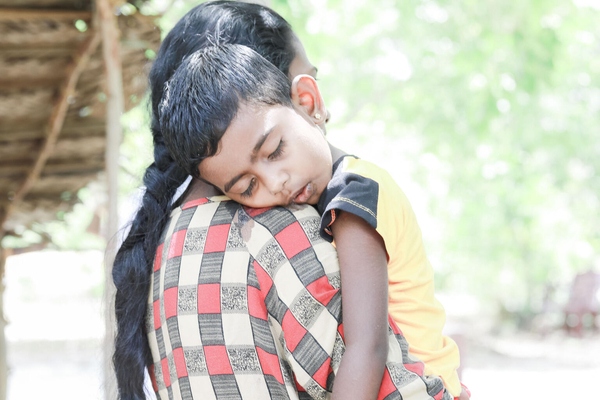 母親に抱かれぐったりしている栄養不良の3歳の子ども。(スリランカ、2022年7月5日撮影)
