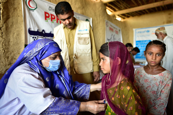 バロチスタン州・Sibi地区のユニセフと保健省が設置した移動式保健キャンプで、健康状態を診てもらう子どもたち。(パキスタン、2022年8月18日撮影)