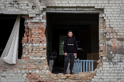 通っていた学校の校舎内に立つ13歳のナザルさん。損傷がひどく、窓ガラスは割れ、壁は剥がれ落ちている。(ウクライナ、2022年8月13日撮影)