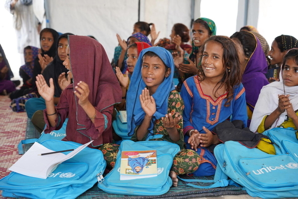 洪水の被害を受けた人々が避難するシンド州のキャンプ内に、ユニセフが設置した仮設学習センターで、授業に参加する子どもたち。(パキスタン、2022年9月16日撮影)