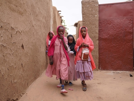 国内避難民キャンプの中を歩く女の子たち。家族と一緒に紛争から逃れてきた。(スーダン、2022年8月2日撮影)