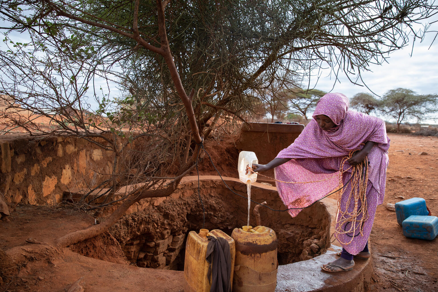 井戸から水を汲み、ポリタンクに入れる14歳のナイマさん（エチオピア）