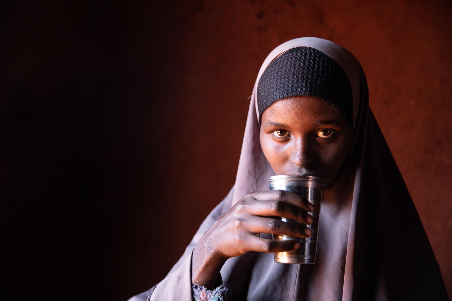 水を飲む18歳のアブディアさん（エチオピア）