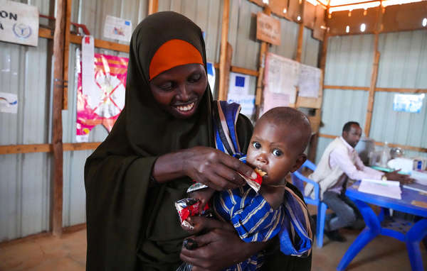 ドロー保健センターで、すぐに食べられる栄養治療食(RUTF)を母親に食べさせてもらう生後10カ月のウバちゃん。(ソマリア、2022年5月撮影)