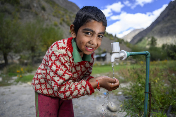 ヒマーチャル・プラデーシュ州の自宅の水道から水を飲む7歳のナブニトくん。(インド、2022年10月7日撮影)