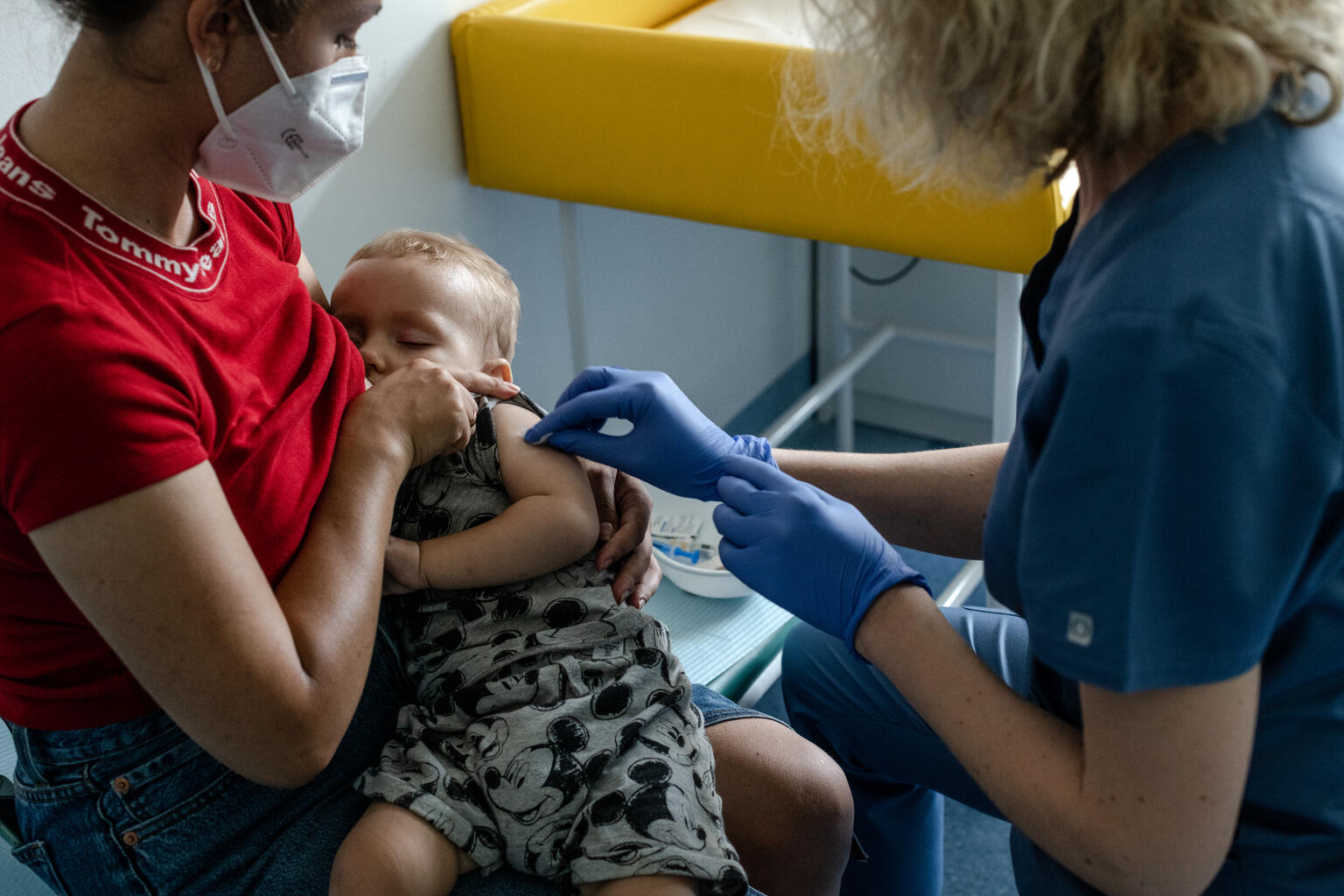 母親のカテリーナさんにに抱かれながら、医療センター予防接種を受ける、マトヴィ（1歳）