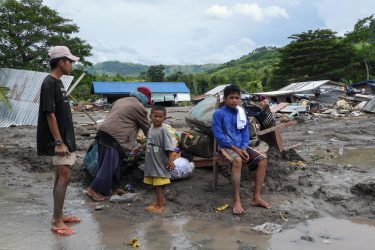 熱帯暴風雨による地滑りの被害を受けた、フィリピン南部にあるマギンダナオ州の村で、破壊された家屋のそばに集まる住民たち。 (フィリピン、2022年10月29日撮影／AFP)