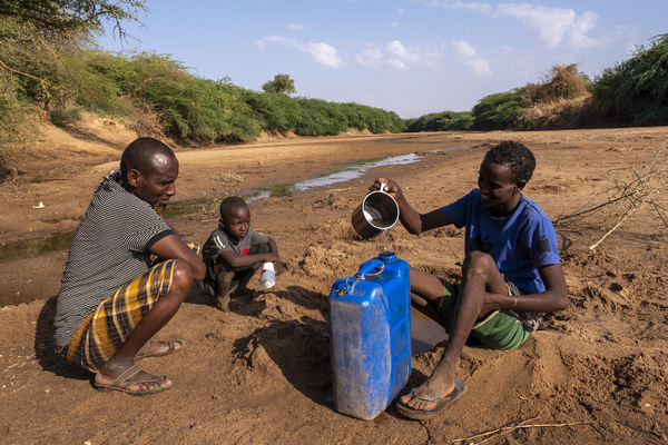 乾いたドロー川から、汚れた水を汲む家族。(ソマリア、2022年3月撮影)