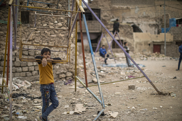 モスルの旧市街で、紛争の被害により崩れた建物のそばにある公園で遊ぶ子どもたち。(イラク、2022年3月撮影)