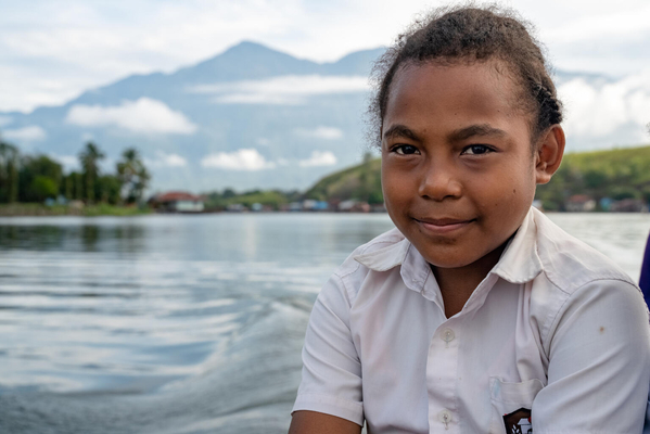 パプア州の農村部から学校へ通学するためにボートを使う、小学6年生のシャーリーさん。パプア州の農村部では、5歳以上の子どもの約50％が学校に行っていないが、都市部は5％のみに留まっており、先住民族の子どもは学校へ通いにくい問題がある。(インドネシア、2022年7月撮影)