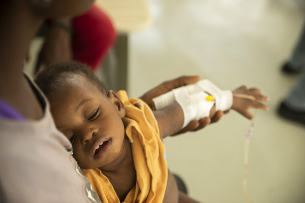 ポルトープランスで、コレラに感染したため、手に点滴をされて治療を受ける子ども。(ハイチ、2022年10月14日撮影)