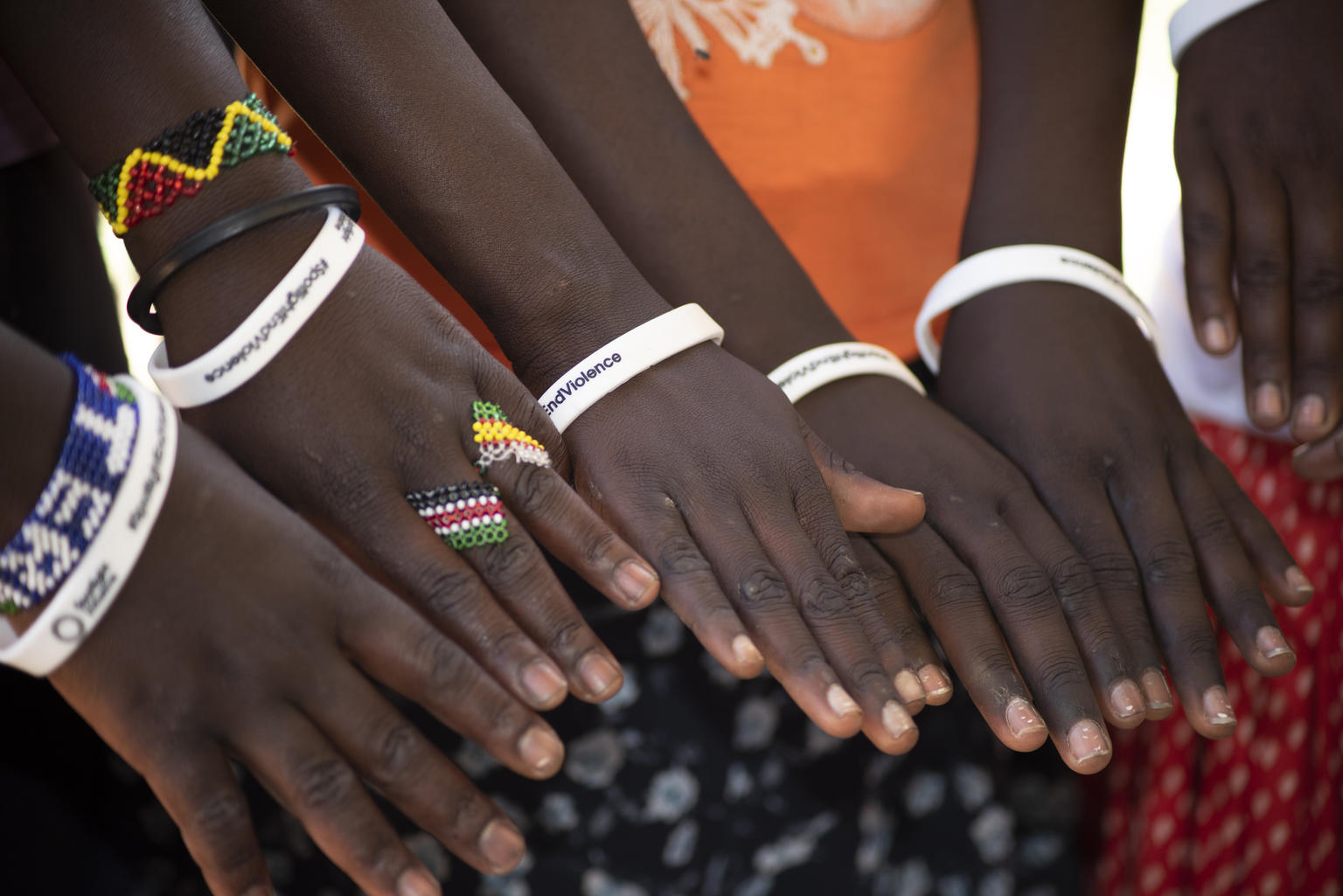 女性器切除(FGM)を強いられたため、隣国ケニアに逃げて、無事に保護されたウガンダの女の子たち。一時的に通っている小学校では、「暴力反対」と書かれたリストバンドを付けてFGM根絶を訴えている。（ウガンダ、2020年撮影）