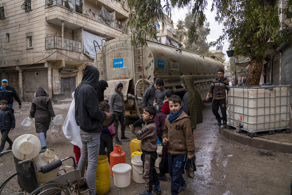 北西部のアレッポで、ユニセフが支援する給水車から容器に安全な水を汲む人たち。(シリア、203年2月10日撮影)