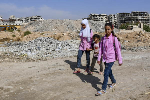 ダマスカスの農村部で、瓦礫の横を通って学校に向かう子どもたち。(シリア、2022年10月撮影)